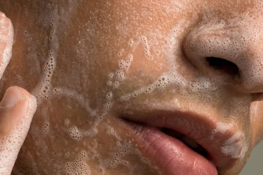 man washing his face with foamy soap